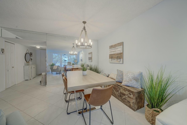 dining area with a chandelier, a textured ceiling, and light tile patterned floors