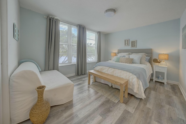 bedroom with baseboards and light wood finished floors