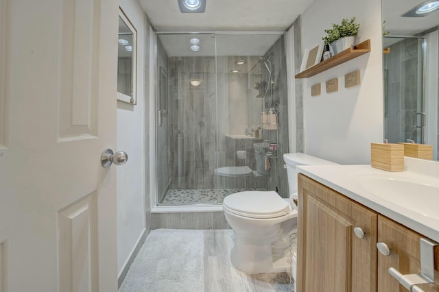 bathroom with toilet, a shower stall, and vanity