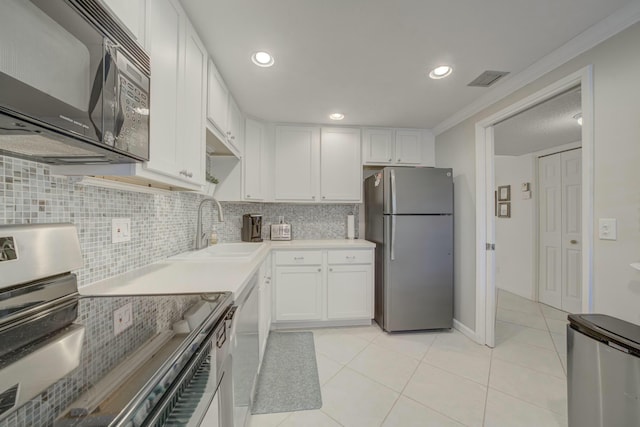 kitchen with a sink, white cabinets, light countertops, appliances with stainless steel finishes, and backsplash