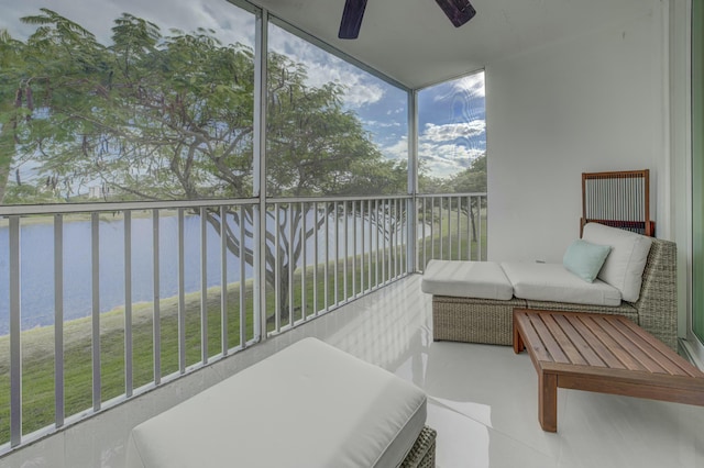 sunroom / solarium featuring a ceiling fan and a water view