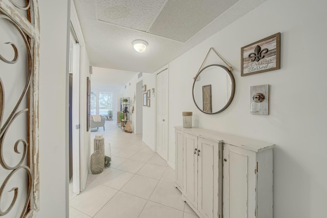 hallway featuring light tile patterned floors and a textured ceiling