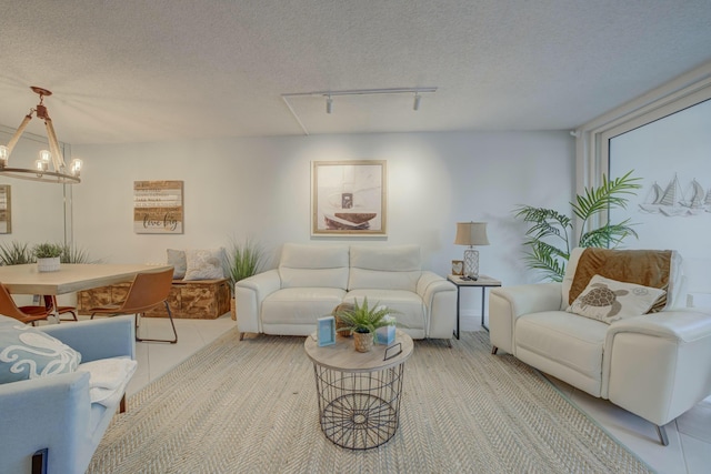 living room featuring light tile patterned floors, a textured ceiling, and an inviting chandelier