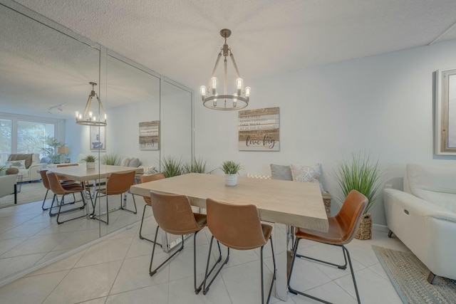 dining area featuring light tile patterned flooring, a notable chandelier, and a textured ceiling