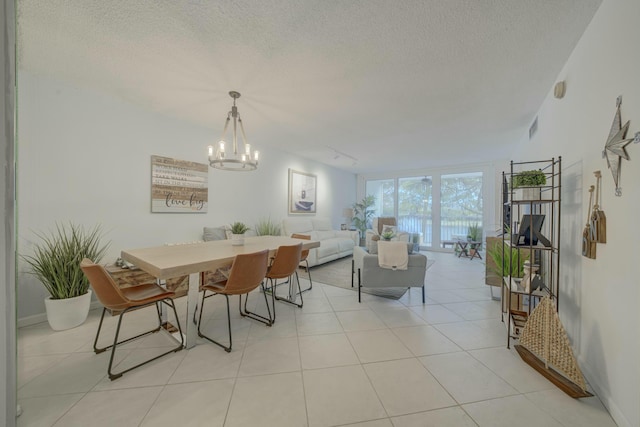 dining space featuring visible vents, a textured ceiling, track lighting, and light tile patterned floors