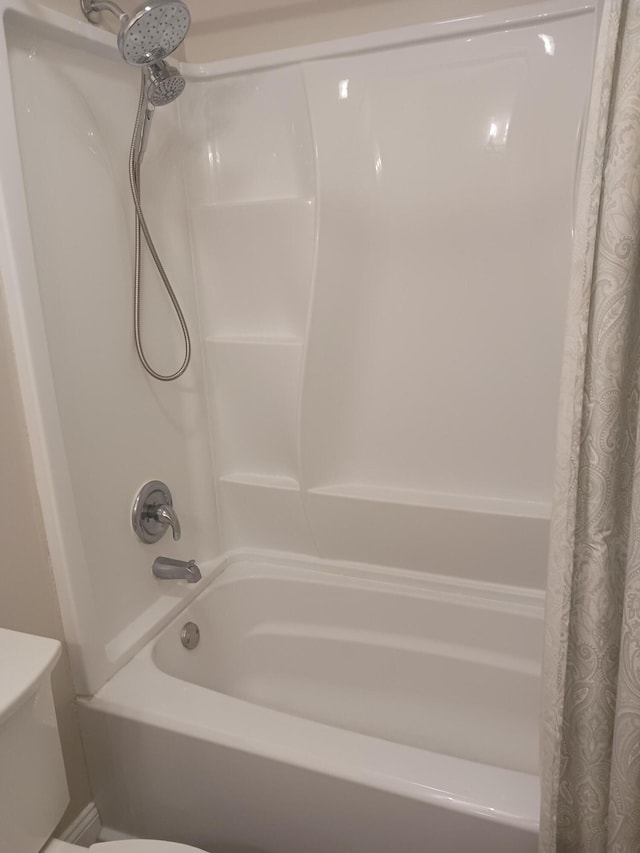 full bathroom featuring shower / tub combo and toilet