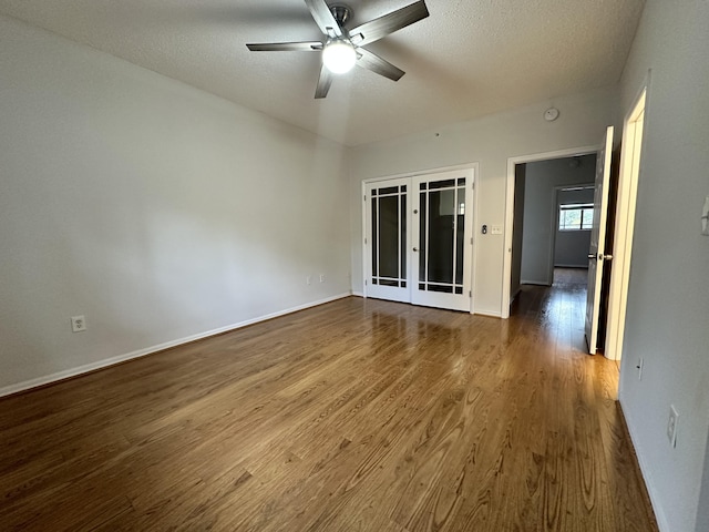 empty room featuring dark wood finished floors, a textured ceiling, and french doors