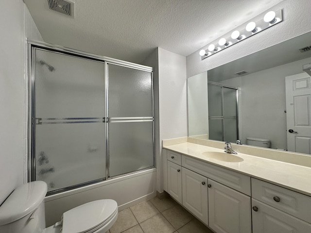 full bathroom featuring a textured ceiling, toilet, shower / bath combination with glass door, visible vents, and tile patterned floors