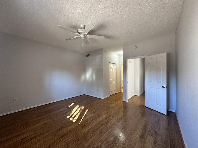 unfurnished bedroom featuring a closet, visible vents, dark wood-type flooring, a textured ceiling, and baseboards