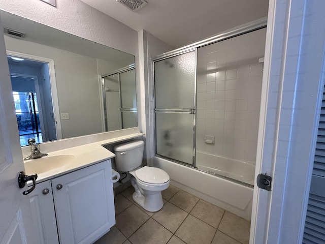 full bath with toilet, vanity, visible vents, combined bath / shower with glass door, and tile patterned floors