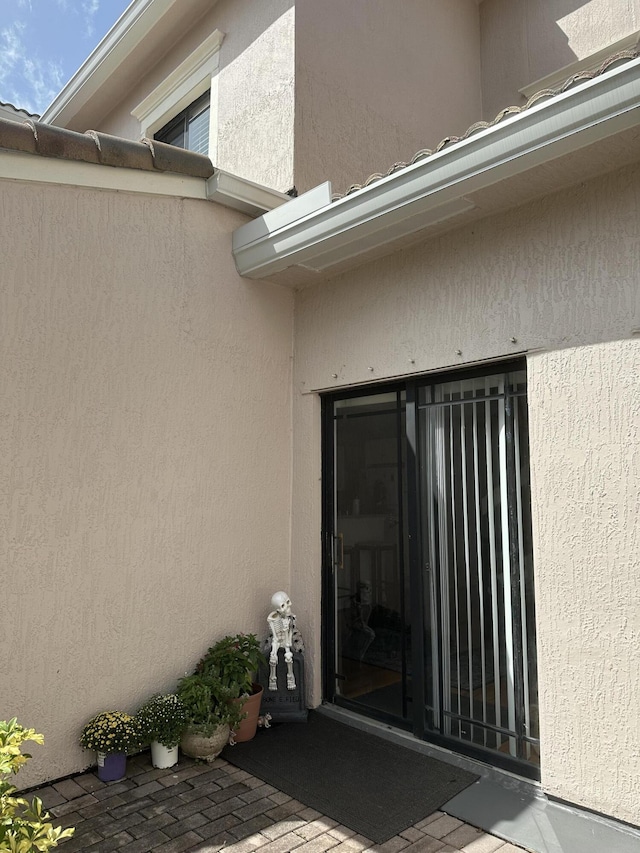 doorway to property featuring stucco siding