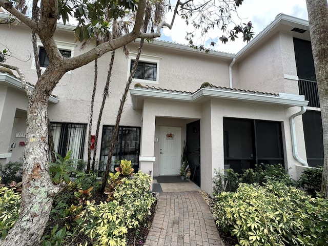 view of front of property featuring a tiled roof and stucco siding