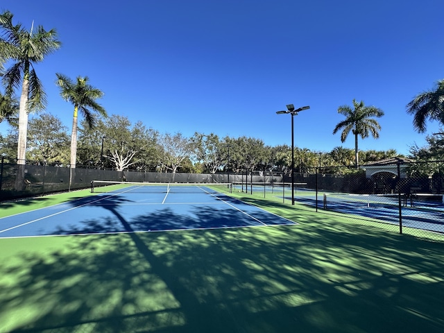 view of tennis court featuring fence