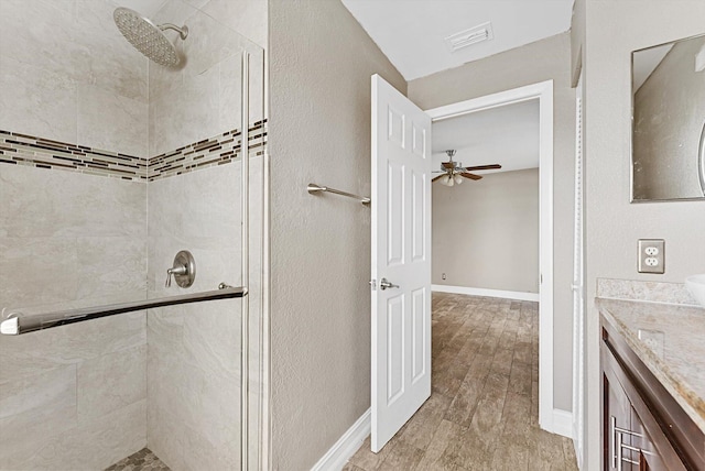 bathroom featuring visible vents, a shower stall, vanity, and wood finished floors