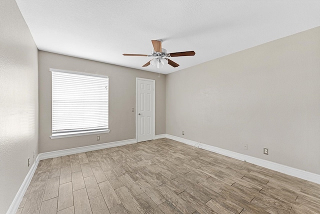 unfurnished room with light wood-style floors, ceiling fan, and baseboards