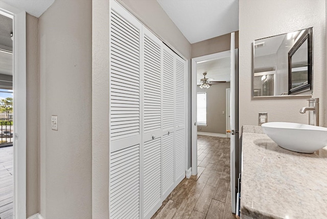 bathroom with baseboards, a ceiling fan, a textured wall, vanity, and wood finish floors