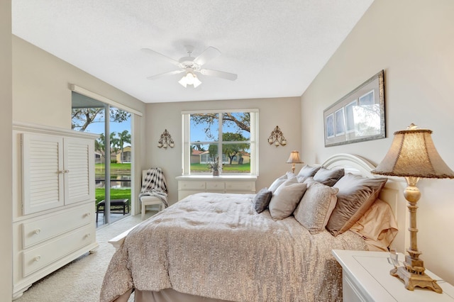 bedroom featuring access to exterior, light colored carpet, ceiling fan, and multiple windows