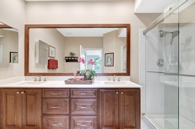 full bath with a sink, double vanity, and a tile shower