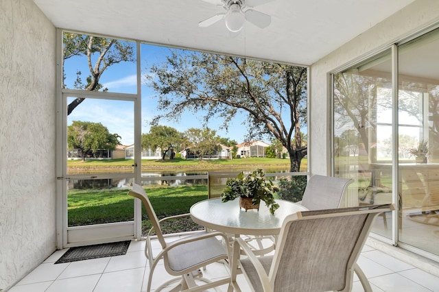 sunroom / solarium featuring a water view and ceiling fan