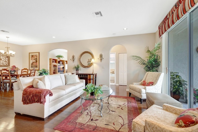 living room with arched walkways, visible vents, recessed lighting, and an inviting chandelier