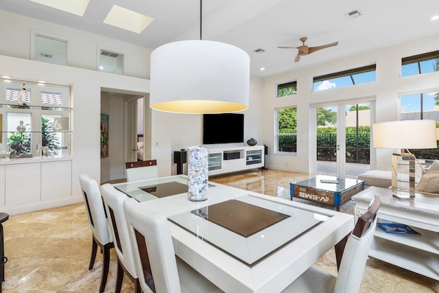 dining room featuring a towering ceiling, visible vents, and french doors