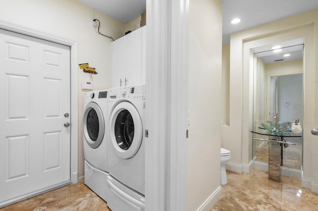 washroom featuring cabinet space, independent washer and dryer, and baseboards