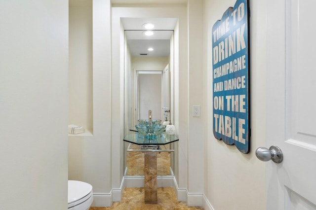 bathroom with toilet and baseboards