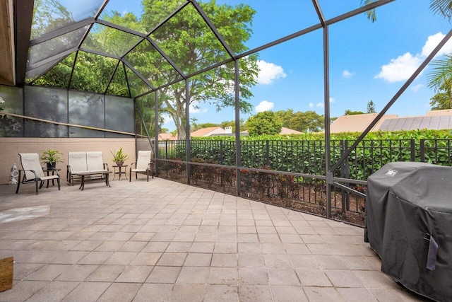 view of patio with a lanai, fence, and grilling area