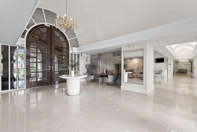 entrance foyer featuring a towering ceiling, a chandelier, and french doors