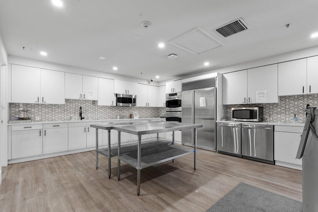 kitchen featuring appliances with stainless steel finishes, light countertops, visible vents, and light wood-style floors