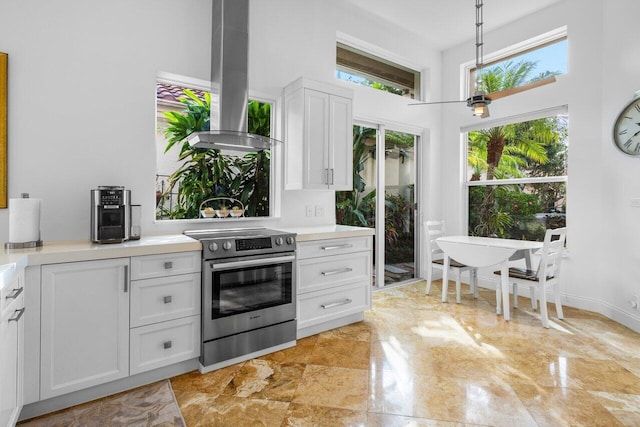 kitchen with white cabinets, island range hood, light countertops, and electric stove