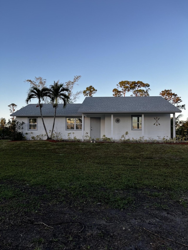 ranch-style house with a front yard and stucco siding