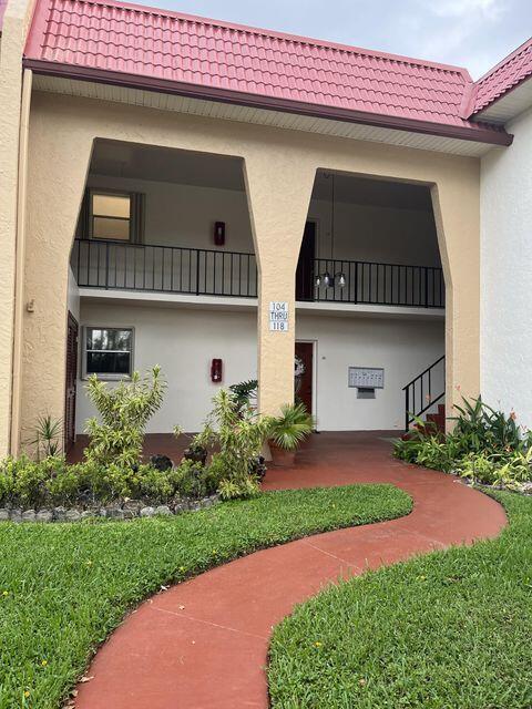 exterior space with a tile roof and stucco siding