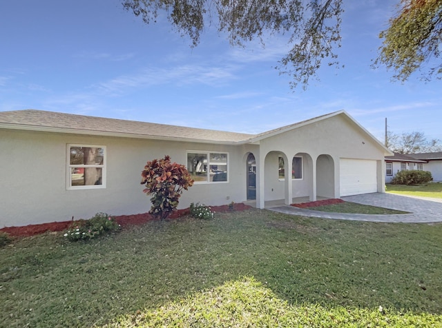 ranch-style house featuring driveway, a front lawn, and stucco siding