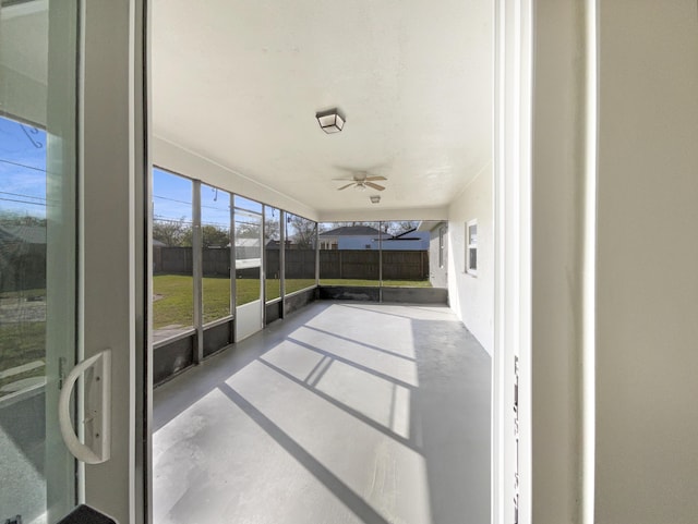 unfurnished sunroom featuring ceiling fan