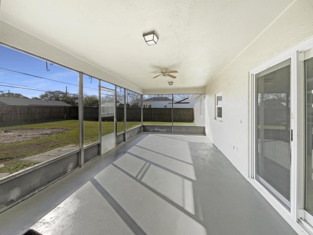 unfurnished sunroom featuring ceiling fan