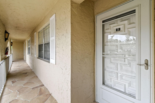 doorway to property featuring stucco siding