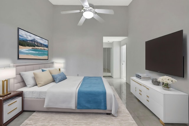 bedroom featuring a towering ceiling, light tile patterned floors, and a ceiling fan