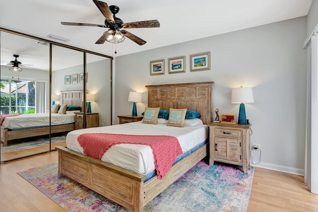 bedroom featuring a closet, light wood-type flooring, a ceiling fan, and baseboards