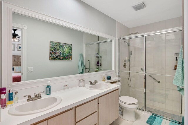 bathroom featuring a sink, a shower stall, toilet, and double vanity