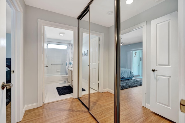 hallway featuring baseboards and wood finished floors