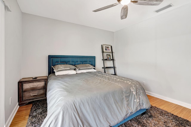 bedroom with visible vents, ceiling fan, baseboards, and wood finished floors