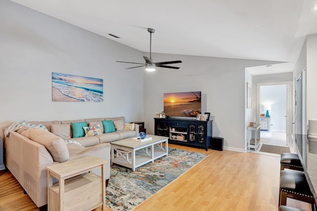 living area featuring a ceiling fan, baseboards, visible vents, and wood finished floors