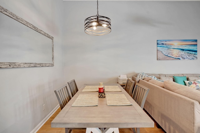 dining space featuring light wood-type flooring and baseboards