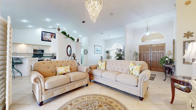 living room featuring a chandelier, high vaulted ceiling, light tile patterned flooring, and visible vents