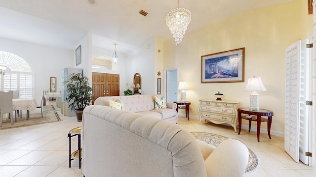 living room with high vaulted ceiling, light tile patterned flooring, visible vents, and an inviting chandelier