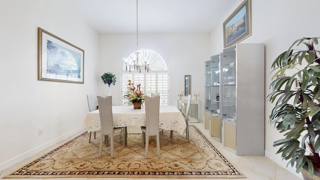 dining area with light tile patterned flooring, baseboards, and an inviting chandelier