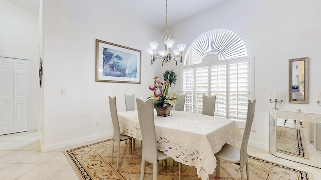 dining room featuring light tile patterned floors, high vaulted ceiling, a chandelier, and baseboards