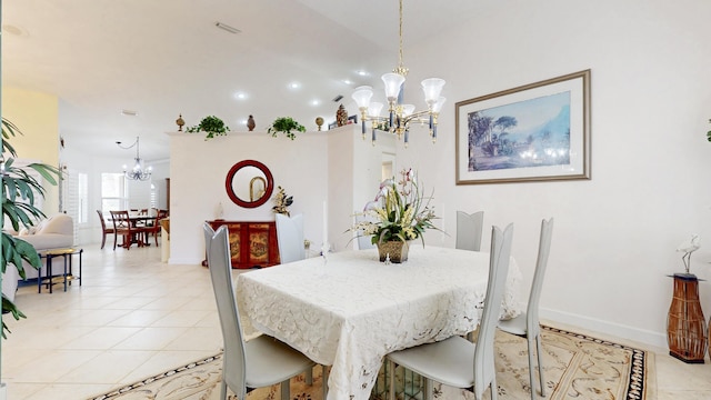 dining area featuring an inviting chandelier, light tile patterned floors, and baseboards