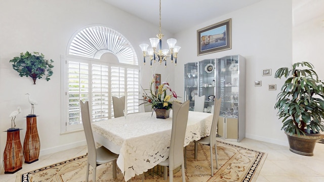 dining area featuring vaulted ceiling, light tile patterned flooring, and baseboards